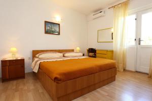 sypialnia z dużym łóżkiem i oknem w obiekcie Apartments by the sea Igrane, Makarska - 10033 w mieście Igrane