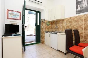 a kitchen with a sink and a tv in a room at Apartments with WiFi Split - 10243 in Split