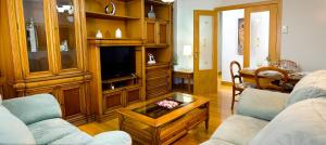 a living room with two couches and a tv at Sestao, Vivienda Turística Renovada con Terraza y WIFI in Sestao