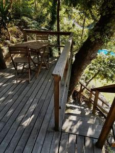 una terraza de madera con mesa y banco en Moinho de Pedra Má, en Arouca