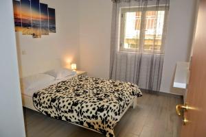 a bedroom with a black and white bed and a window at Apartments by the sea Brna, Korcula - 10065 in Brna