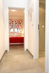 Apartment Duce 10304b في دوسيه: غرفة نوم بسرير احمر ونافذة