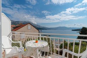 balcón con mesa, sillas y vistas al agua en Apartments by the sea Korcula - 10051 en Korčula