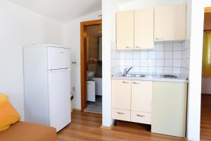 a white kitchen with a sink and a refrigerator at Apartments by the sea Zuronja, Peljesac - 10123 in Brijesta