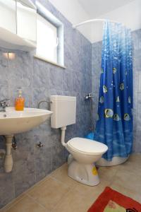 a bathroom with a toilet and a blue shower curtain at Apartment Zuronja 10137b in Brijesta