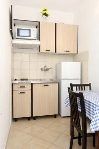 a kitchen with a white refrigerator and a microwave at Apartment Zuronja 10137b in Brijesta