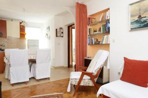 a kitchen and dining room with white chairs and a table at Apartment Zuljana 10112a in Žuljana