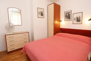a bedroom with a bed and a dresser and a mirror at Apartment Zuljana 10112a in Žuljana