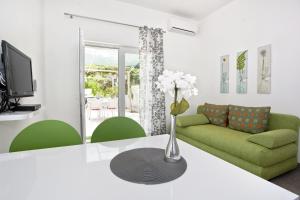 un soggiorno con divano verde e tavolo di Apartment Duce 10304c a Duće