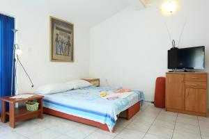 a small bedroom with a bed and a tv at Apartments by the sea Zuljana, Peljesac - 10218 in Žuljana