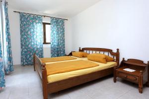 a bedroom with a large bed with blue curtains at Apartments by the sea Drace, Peljesac - 10126 in Drače