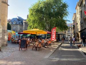 een groep mensen in een restaurant onder paraplu's bij Le Saint-Rémy, hyper centre, calme in Dieppe