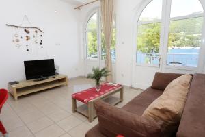 a living room with a couch and a tv at Apartments by the sea Trstenik, Peljesac - 10110 in Trstenik