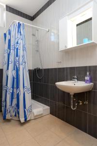 a bathroom with a shower curtain and a sink at Apartments by the sea Trstenik, Peljesac - 10110 in Trstenik