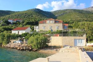 a house on the shore of a body of water at Apartments by the sea Kuciste, Peljesac - 10095 in Kučište