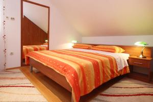 a bedroom with a bed with an orange comforter at Apartments by the sea Kuciste, Peljesac - 10095 in Kučište