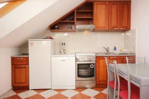 uma cozinha com um frigorífico branco e uma mesa em Apartments by the sea Kuciste, Peljesac - 10095 em Kuciste