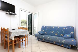 a living room with a blue couch and a table at Apartment Drace 10127c in Drače