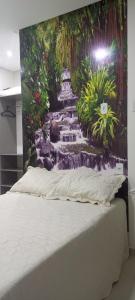 uma cama num quarto com uma pintura de uma cascata em CASA CONFORTÁVEL COM 4 QUARTOS EM ALTER DO CHÃO em Alter do Chão