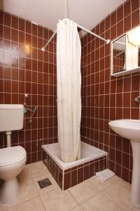 a bathroom with a toilet and a shower curtain at Apartments and rooms with parking space Orebic, Peljesac - 10192 in Orebić