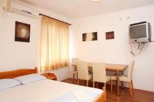 a room with a table and chairs and a tv at Apartments and rooms with parking space Orebic, Peljesac - 10192 in Orebić