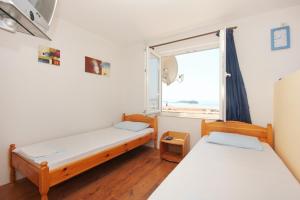 a room with two beds and a window at Apartments and rooms with parking space Orebic, Peljesac - 10192 in Orebić