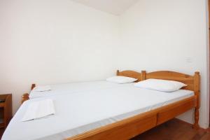 two twin beds in a room with white walls at Twin Room Orebic 10192a in Orebić