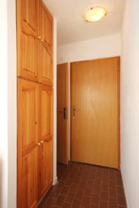 a hallway with a wooden door and a tile floor at Twin Room Orebic 10192a in Orebić