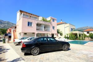 a black car parked in front of a house at Apartments with a swimming pool Orebic, Peljesac - 10166 in Orebić