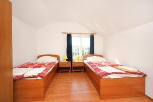 two beds in a room with a window at Apartments by the sea Viganj, Peljesac - 10189 in Kučište