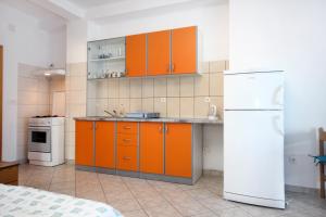 a kitchen with orange cabinets and a white refrigerator at Apartments by the sea Viganj, Peljesac - 10189 in Kučište +29 photos