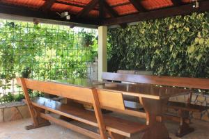 a table and benches in front of a green wall at Apartments by the sea Loviste, Peljesac - 10255 in Lovište