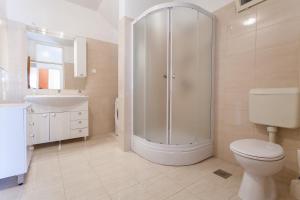 a bathroom with a shower and a toilet and a sink at Apartments by the sea Lumbarda, Korcula - 10049 in Lumbarda +24 photos