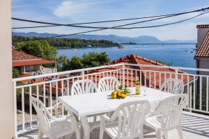a white table and chairs on a balcony with a view of the water at Apartments by the sea Lumbarda, Korcula - 10049 in Lumbarda