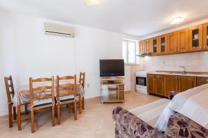 a kitchen with a table and chairs in a room at Apartments by the sea Lumbarda, Korcula - 10049 in Lumbarda