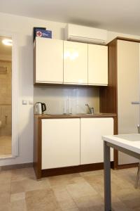 a kitchen with white cabinets and a sink at Apartments by the sea Korcula - 10054 in Korčula