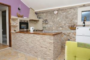 a stone kitchen with a counter and a refrigerator at Seaside holiday house Cove Vela Prapratna (Peljesac) - 9486 in Oskorušno +14 photos