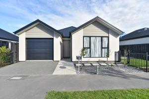 una casa blanca con garaje en Thomas Townhouse - Christchurch Holiday Homes en Christchurch