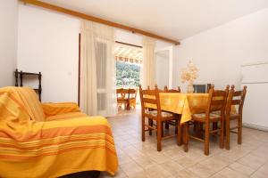 a bedroom with a table and chairs and a dining room at Apartments by the sea Brna, Korcula - 10057 in Smokvica
