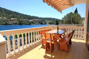 a table and chairs on a balcony with a view of the water at Apartments by the sea Brna, Korcula - 10057 in Smokvica