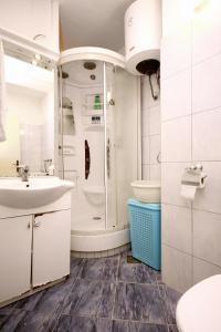 a bathroom with a sink and a shower and a toilet at Holiday apartments Split - 10315 in Split