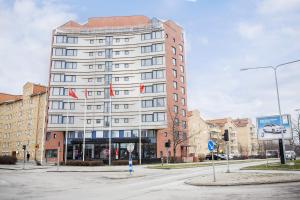 a tall white building with flags in front of it at 2Home Hotel Apartments in Solna