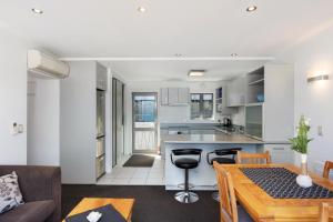 a kitchen and living room with a table and a couch at Ballarat Bungalow in Queenstown