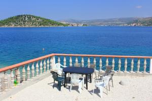 een tafel en stoelen op een balkon met uitzicht op het water bij Apartment Razanj 10318a in Rogoznica