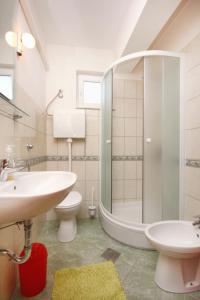W łazience znajduje się umywalka, toaleta i prysznic. w obiekcie Apartment Razanj 10318a w Rogoznicy