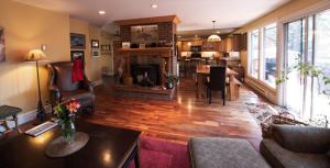 a large living room with a fireplace and a dining room at Auberge Kicking Horse Guest House in Golden