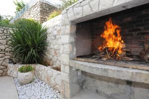 a brick fireplace with a fire in it at Apartments by the sea Seget Vranjica, Trogir - 10328 in Seget Vranjica