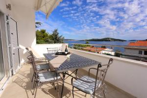 a table and chairs on a balcony with a view of the water at Apartments by the sea Seget Vranjica, Trogir - 10328 in Seget Vranjica