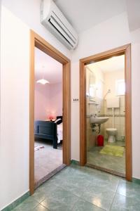 łazienka z drzwiami otwieranymi na łazienkę z umywalką w obiekcie Apartments by the sea Razanj, Rogoznica - 10318 w Rogoznicy
