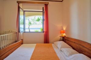 a bedroom with a bed and a window at Apartments by the sea Prizba, Korcula - 10063 in Prizba